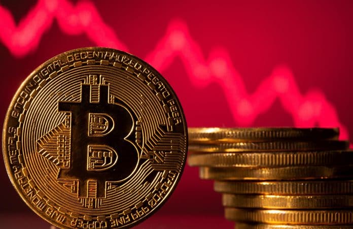 A representations of virtual currency Bitcoin is seen in front of a stock graph in this illustration
