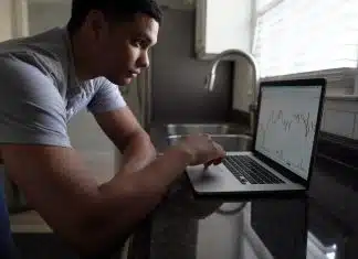 man in gray t-shirt using macbook pro