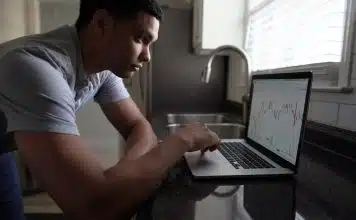 man in gray t-shirt using macbook pro