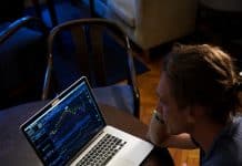 man sitting in front of the MacBook Pro