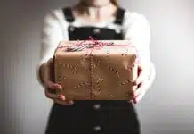 person showing brown gift box